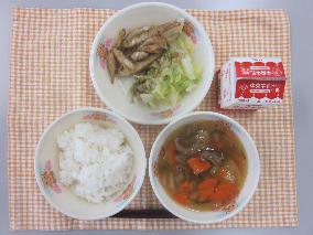 テーブルクロスに並べられたごはん・牛乳・肉だんごとはくさいのスープ・わかさぎのから揚げ・ボイルキャベツ・パックソースの写真