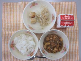テーブルクロスに並べられたごはん・牛乳・マーボーどうふ・えびしゅうまい・ボイルもやし・パックしょうゆの写真