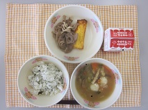テーブルクロスに並べられたわかめごはん・牛乳・白玉ぞう煮・厚焼きたまご・れんこん炒めの写真