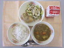 テーブルクロスに並べられた麦ごはん・牛乳・米粉のチキンカレーライス・米粉のほきフライ・ひじきと大豆のサラダ・ごまドレッシングの写真