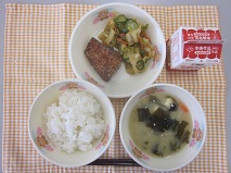 テーブルクロスに並べられたごはん・牛乳・白みそ汁・さばの竜田揚げ・ごまあえの写真