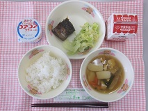 テーブルクロスに並べられたごはん・牛乳・はちはい汁・かつおのおかか煮・しんこあえ・ヨーグルトの写真