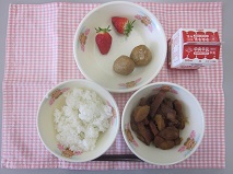 テーブルクロスに並べられたごはん・牛乳・煮みそ・レバー入りつくね・いちごの写真