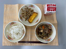 テーブルクロスに並べられたごはん・牛乳・すきやき・厚焼きたまご・れんこんのおかか炒めの写真
