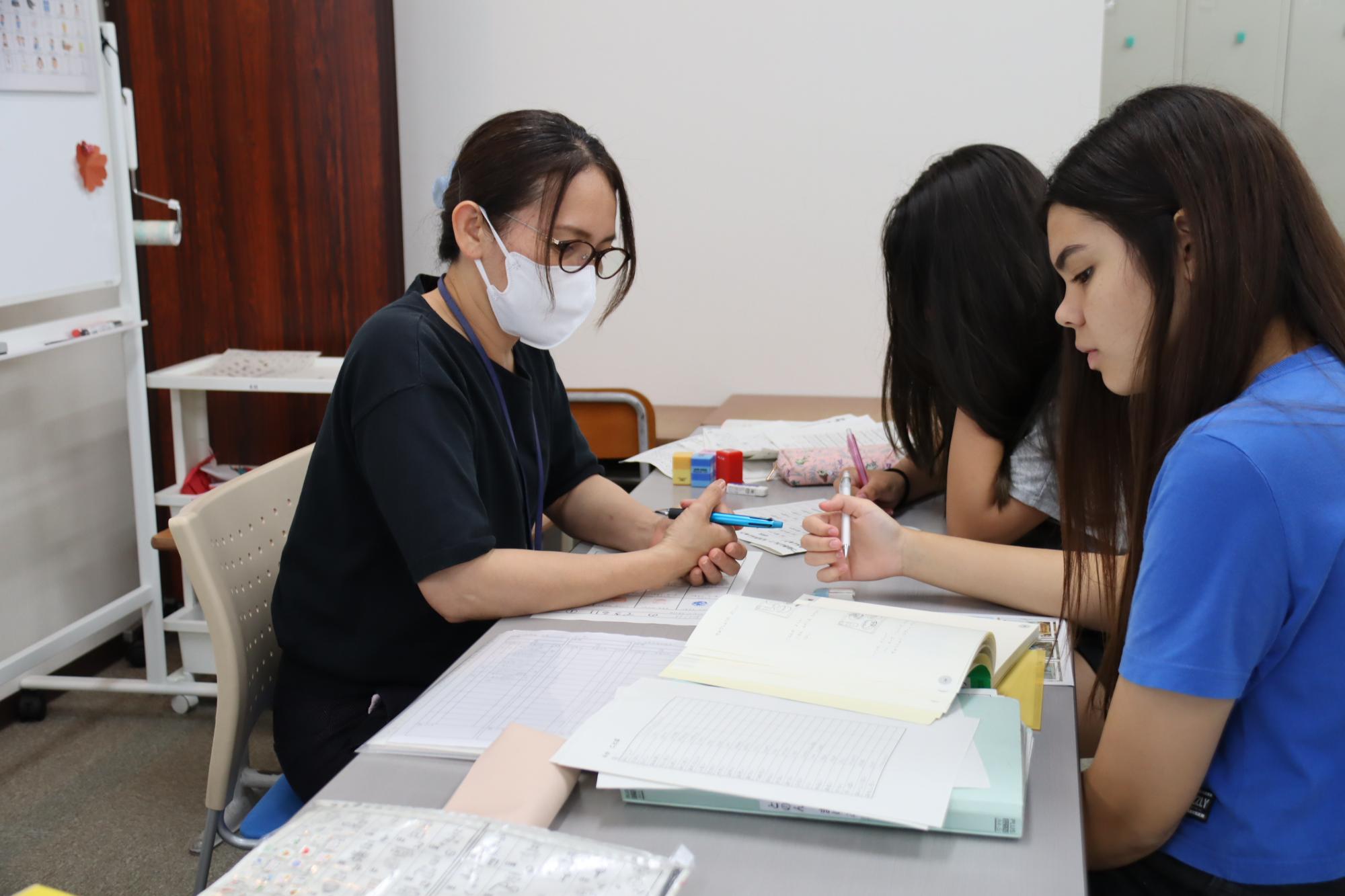 外国人生徒に勉強を教える木村さん