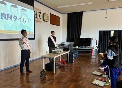 模擬投票に立候補した二人の立候補者に対して、児童が質問をする様子の写真です。