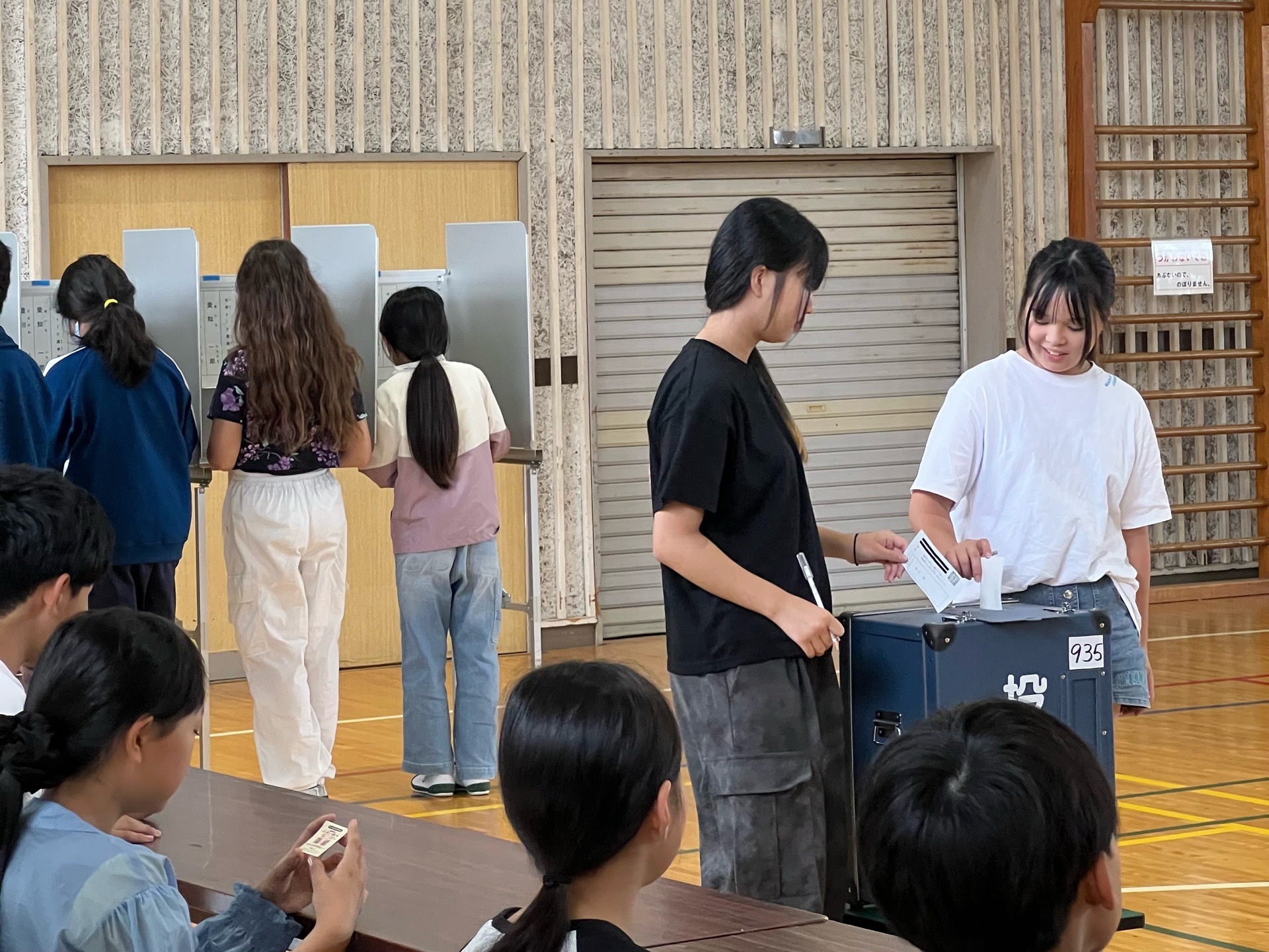 模擬投票を行う代田小学校の児童の写真です。