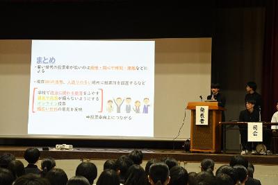 代表生徒が体育館の壇上で発表を行いました。