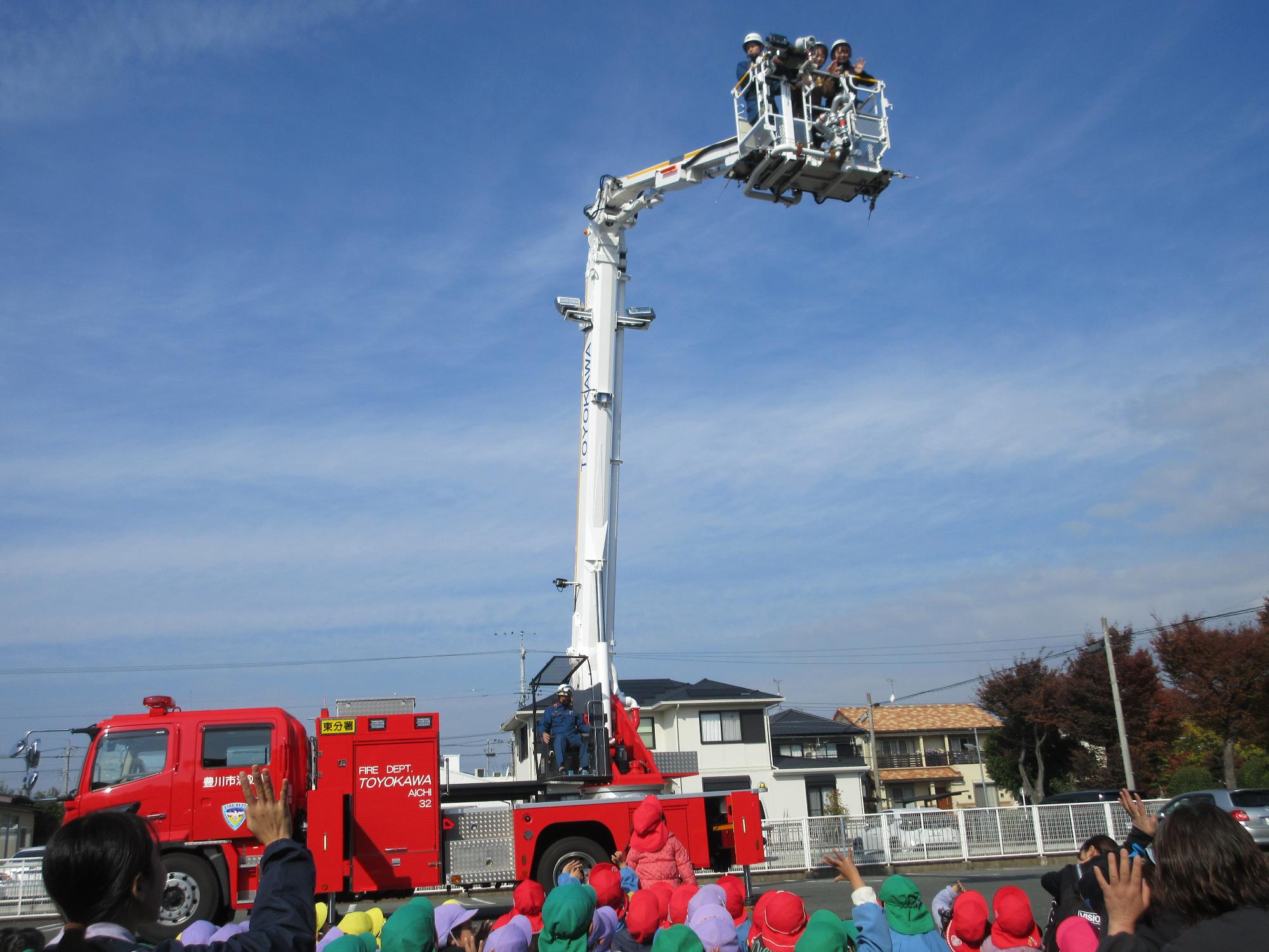 保育士がはしご車に乗って高いところにいる