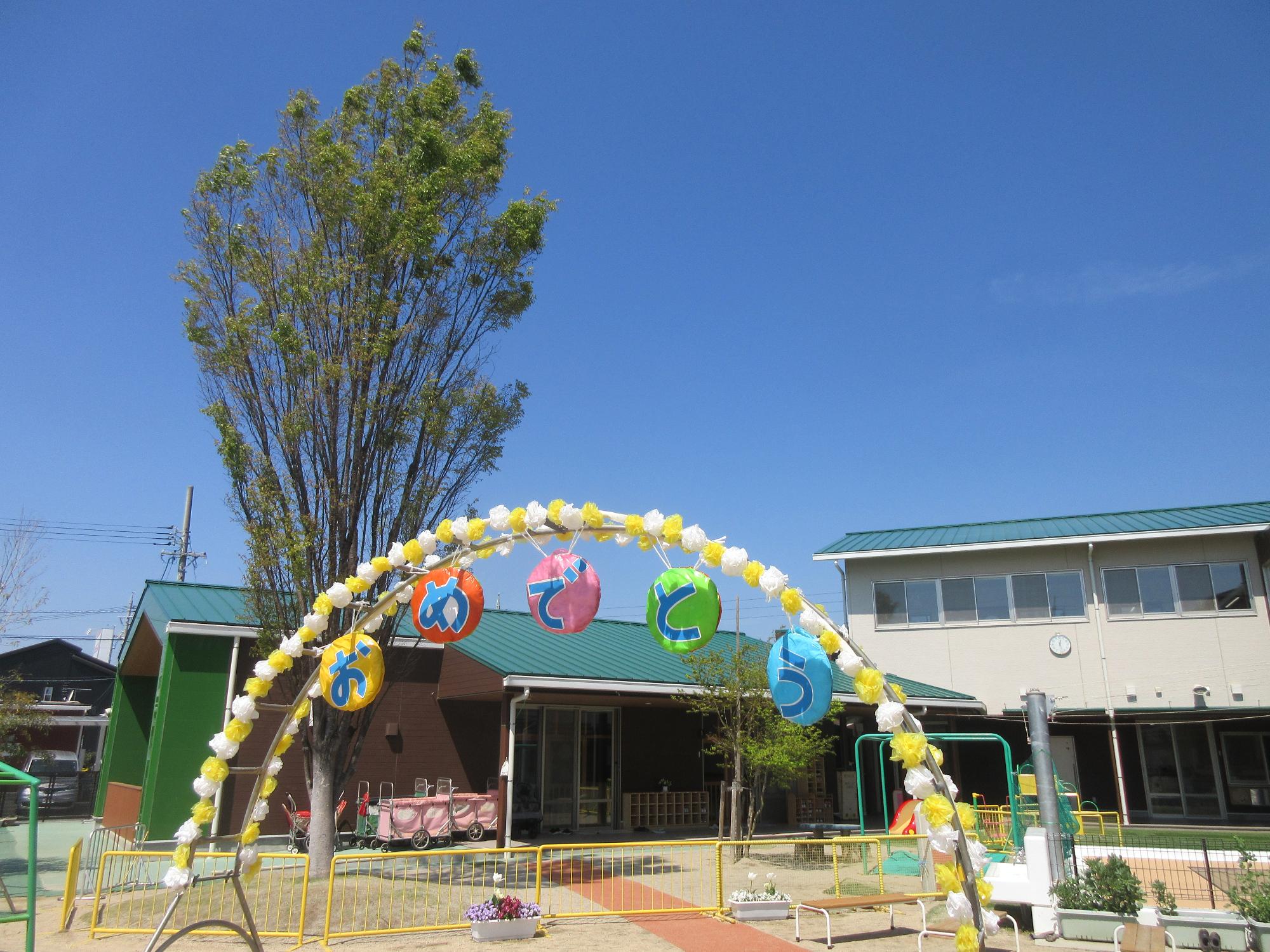 入園式の写真。「にゅうえんおめでとう」と書かれたアーチが置かれている。