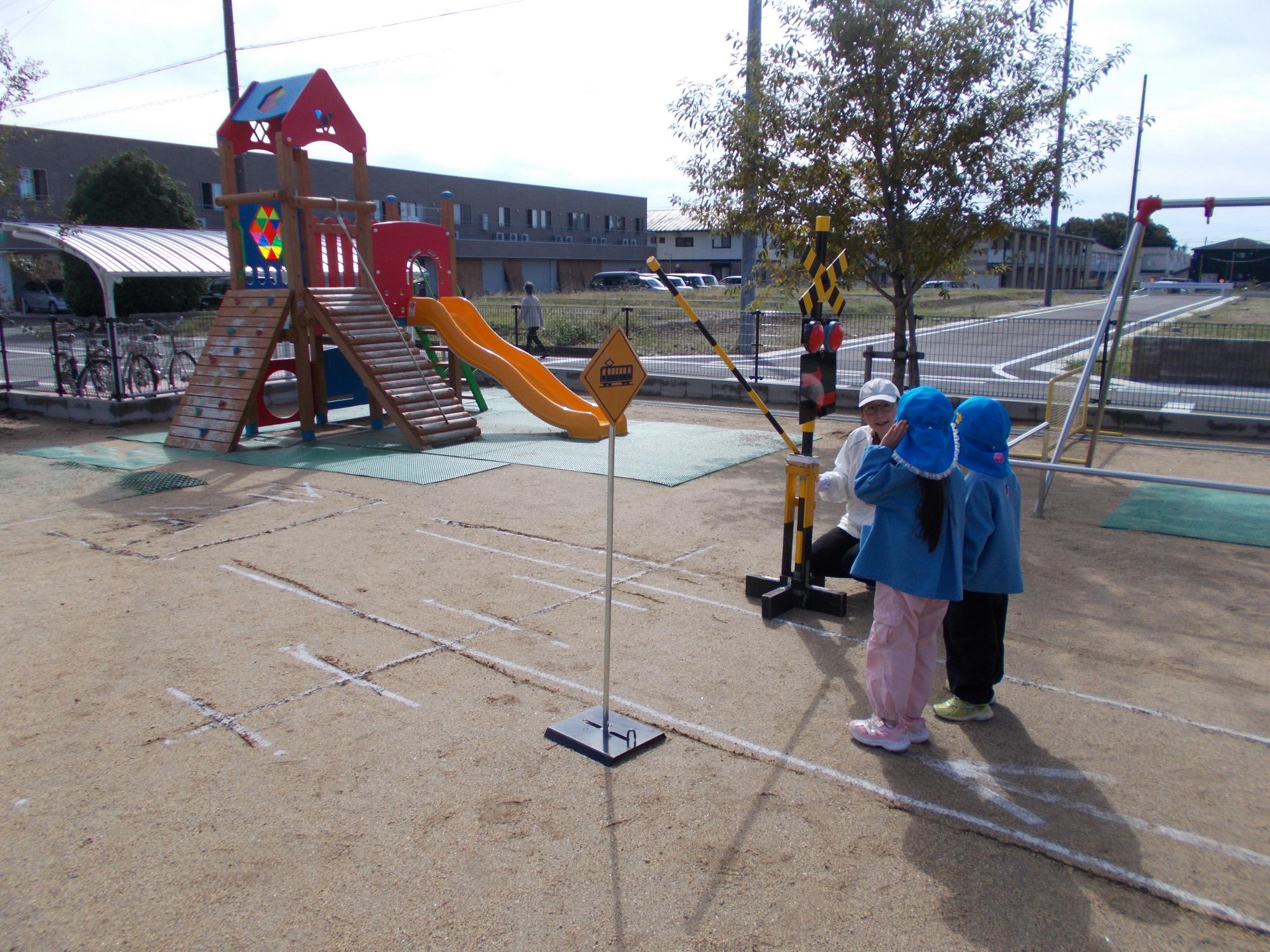 交通安全教室用に設置された踏切で踏切を渡る練習をする子どもたち