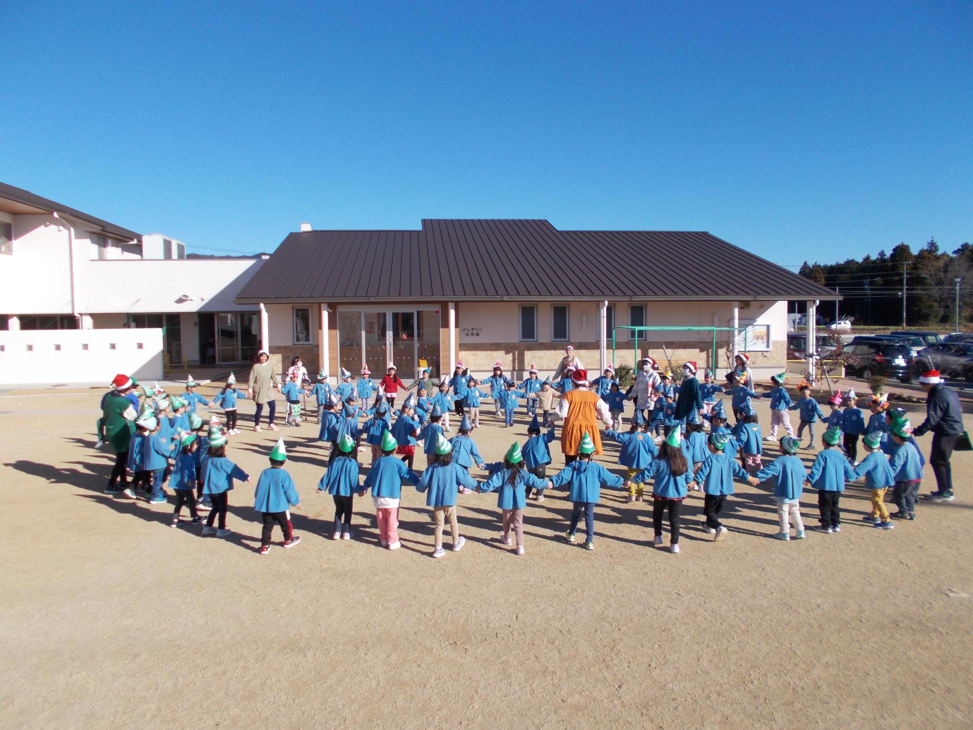 クリスマスのフォークダンスを踊る子どもたち