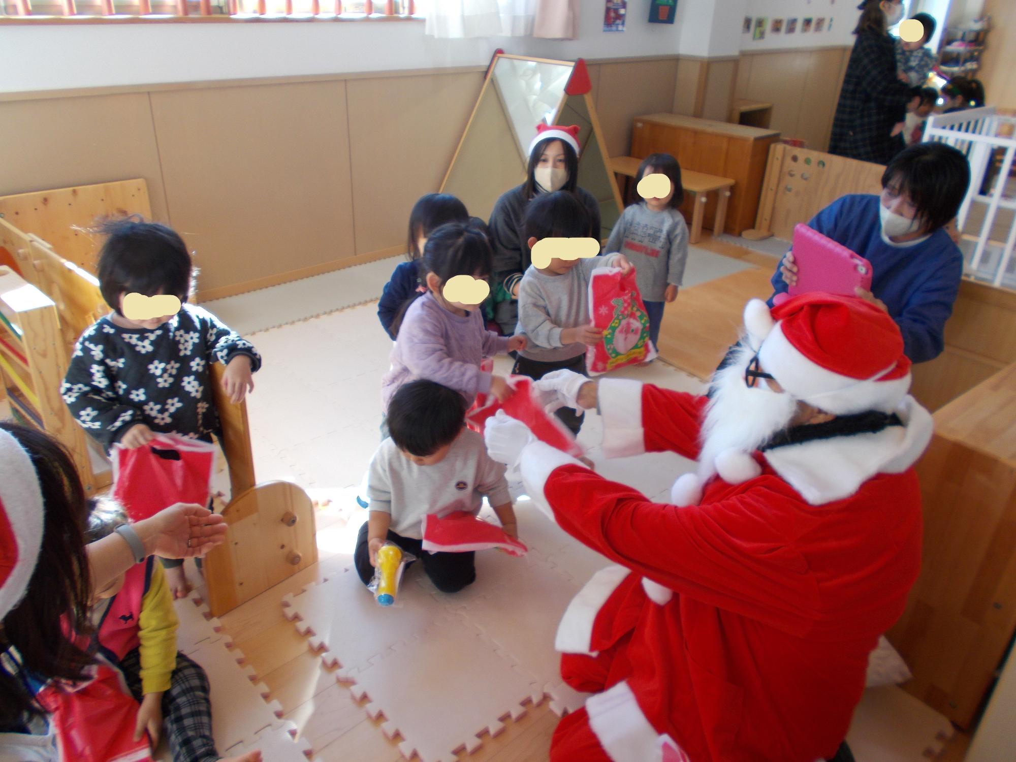 サンタさんにプレゼントをもらう1歳児