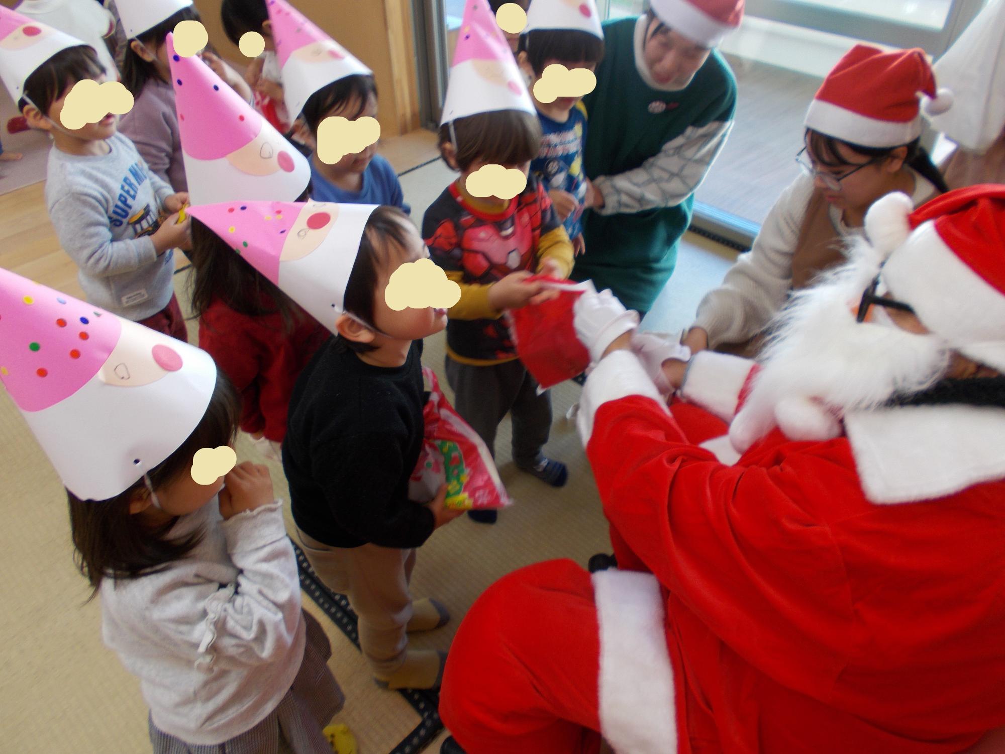 サンタさんを囲んで大喜びの子どもたち