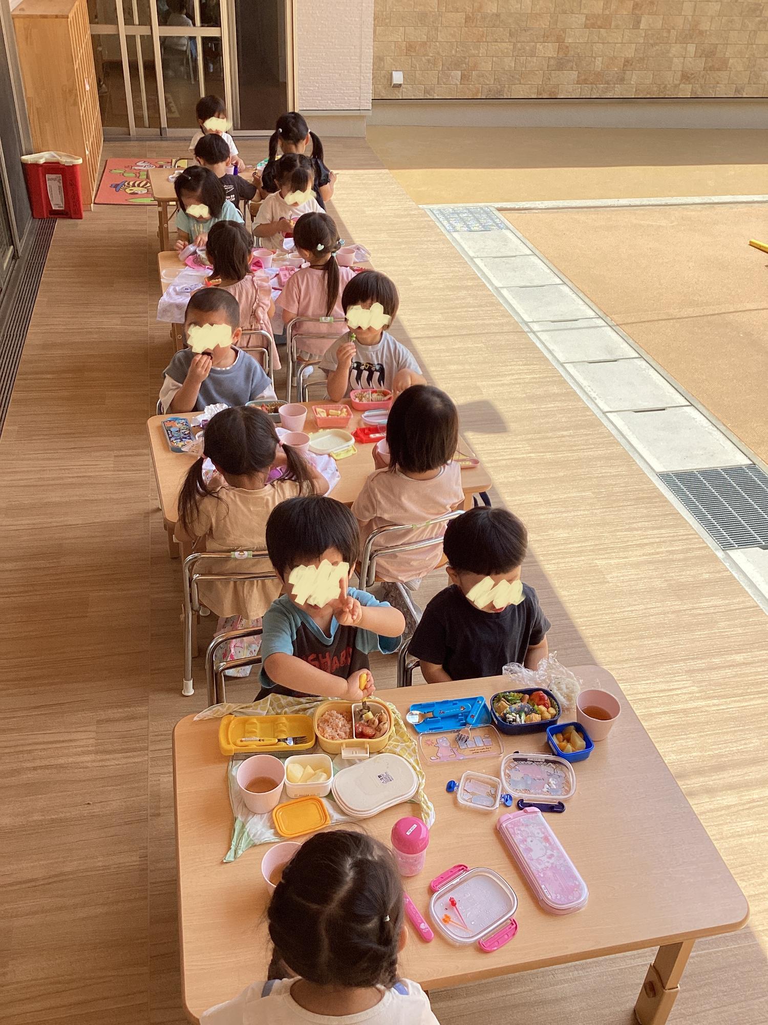 テラスでお弁当を食べる3歳児