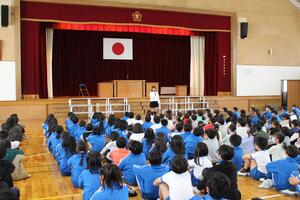 児童たちが体育館で児童集会を行っている写真