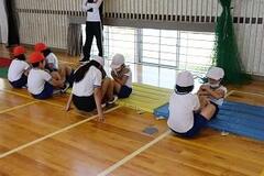 児童たちが二人一組になって上体起こしをしている写真