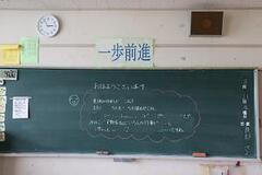 黒板の上に一歩前進と書かれた紙が貼られている写真